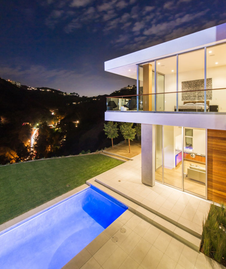 Looking past the pool, family room and master suite toward Laurel Canyon Boulevard below at night.