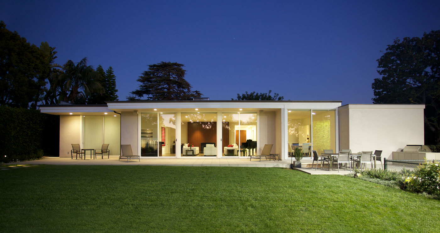 A view of the Brentwood Residence, a restored mid century home, from the backyard at night.