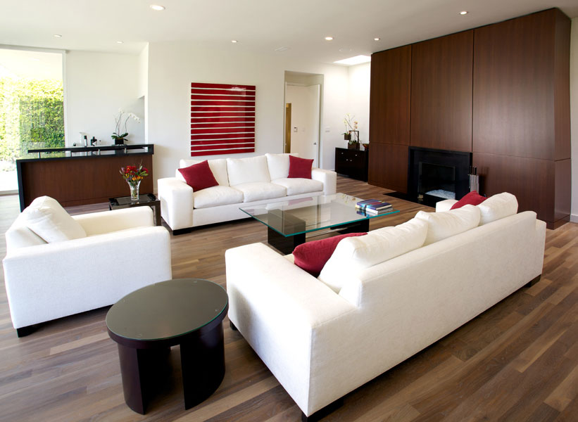 The living room with dark walnut paneling and a rich wood floor.
