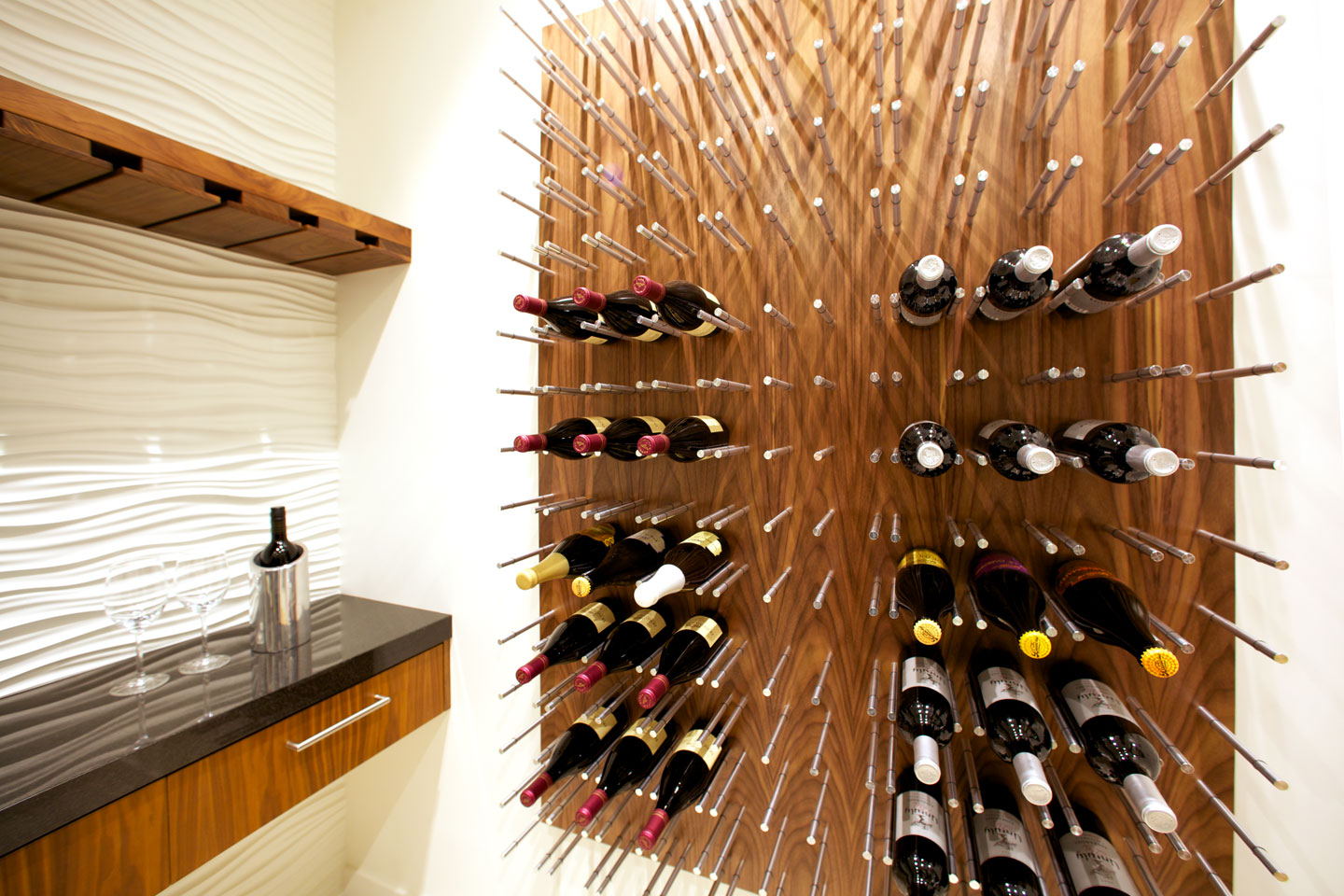 The wine room: a full, modern wine rack and textured wall.