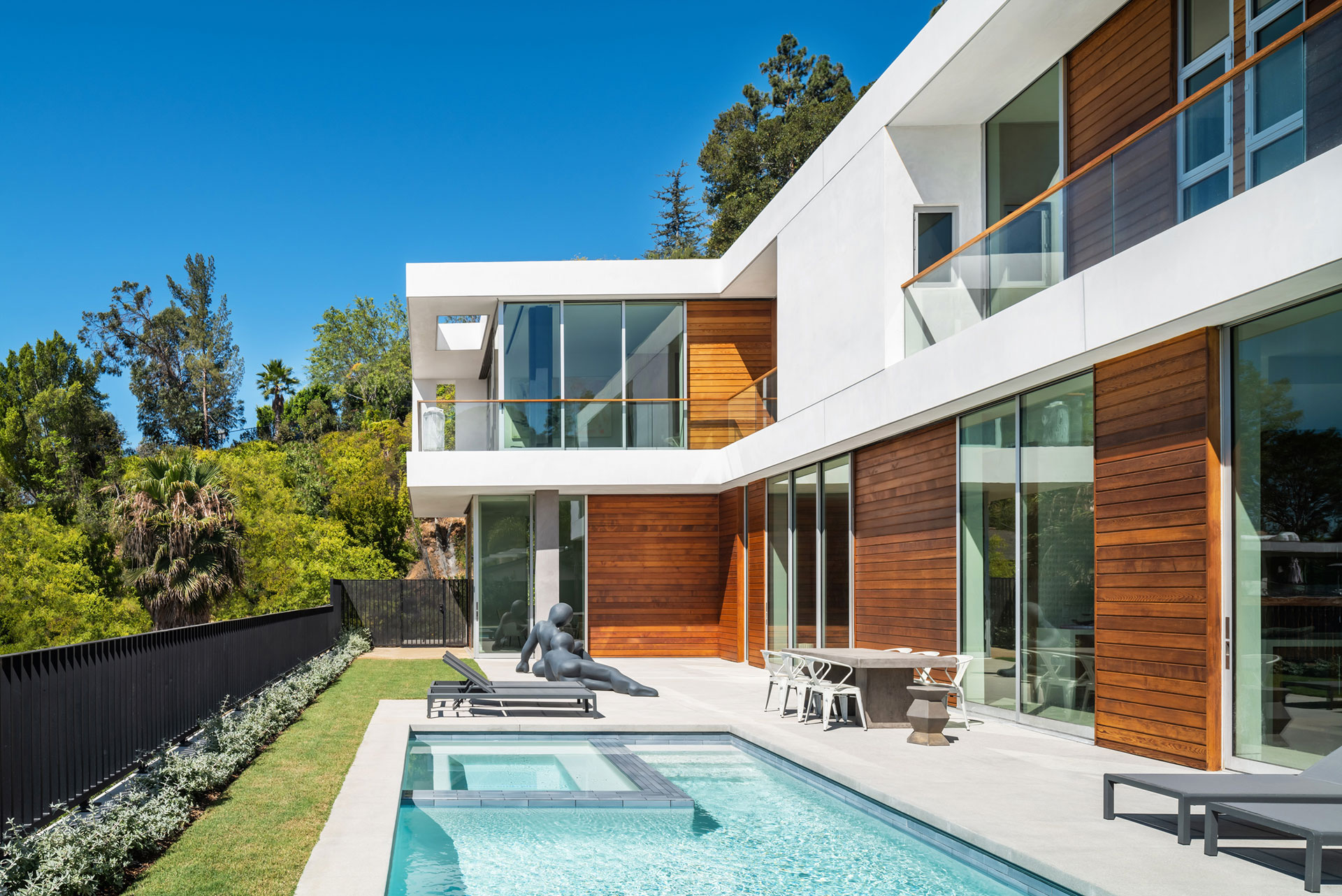 Shadows play across the wood siding and in the deep punched second floor balconies. Photo: © Paul Vu, Here and Now Agency