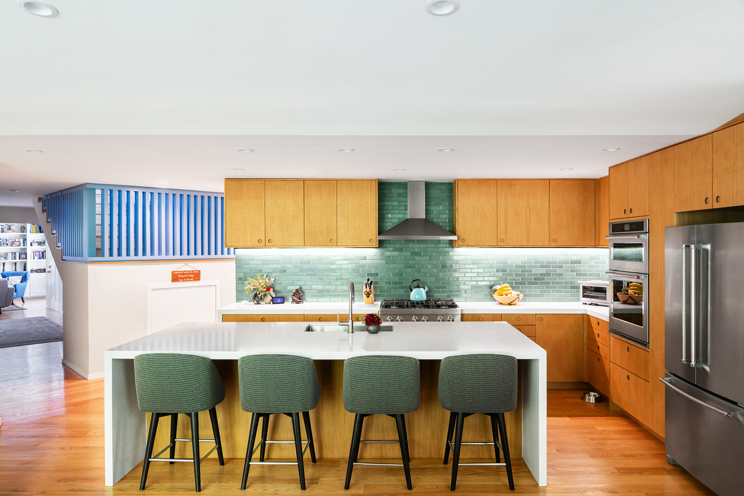 The view from the Family Room and Kitchen in the addition, past the stair to the Living Room in the original house beyond. The kitchen backsplash is from Heath Ceramics and the cabinets are by Reform. Photo: ©Paul Vu, Here and Now Agency