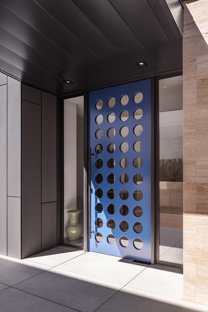The custom glass and steel front door weighs about 950 pounds but requires little effort to open due to the heavy-duty pivot. Photo: ©Paul Vu, Here and Now Agency
